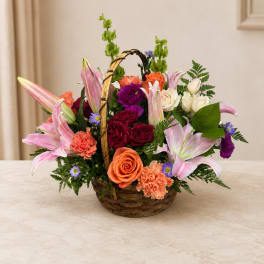 Mixed flower basket with lilies, roses, and carnations in a wicker basket