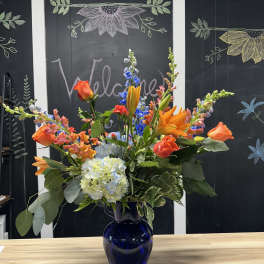 Colorful mixed bouquet in a blue glass vase
