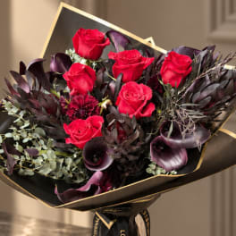 Bouquet of red roses with dark purple flowers and black wrap