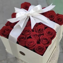 Box of red roses tied with a white ribbon