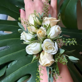 White rose wrist corsage with eucalyptus and small green accents