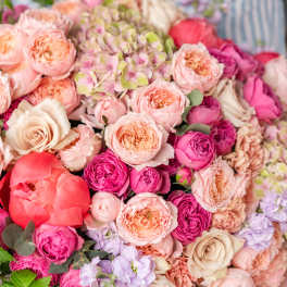 Large bouquet of pink and peach roses with a coral peony