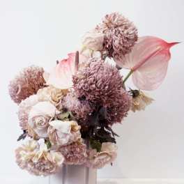 Pink and cream floral arrangement in a pale vase