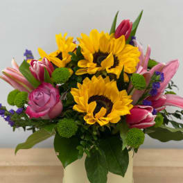 Bouquet with sunflowers, pink tulips, and roses in a vase