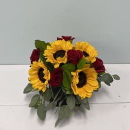 Sunflowers and red roses arranged in a low bouquet