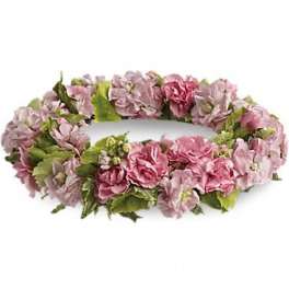 Pink floral wreath with green leaves on a white background