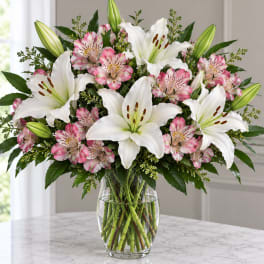 White lilies and pink alstroemeria in a clear glass vase