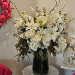 White floral arrangement in a dark glass vase