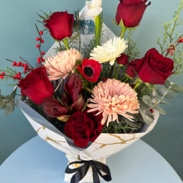 Bouquet of red roses, pale chrysanthemums, and white blooms in wrapped paper