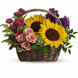 Basket arrangement with sunflowers, pink roses, and purple flowers