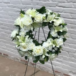 White floral wreath on a black stand