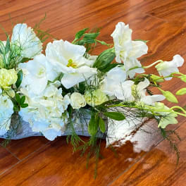 White floral centerpiece with orchids and roses on a low base