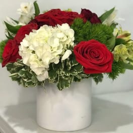 Red roses and white hydrangea in a white vase