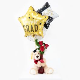 Graduation balloon bouquet with roses and a teddy bear in a vase