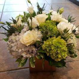 White roses and green hydrangeas in a low square container