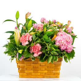 Pink flowers and lilies arranged in a woven basket