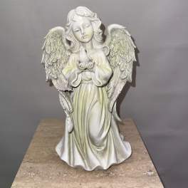 White angel figurine holding a small bird