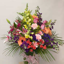 Mixed bouquet in a glass vase with pink, purple, orange, and yellow flowers