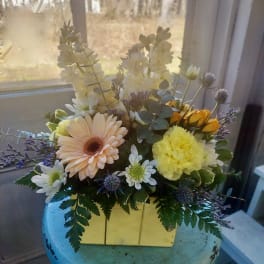 Mixed bouquet in a yellow box with daisies and carnations