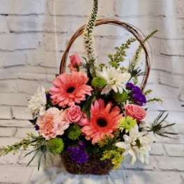 Basket arrangement with pink gerberas, roses, and white daisies