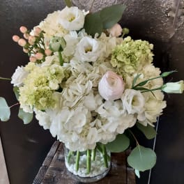 White and pale green bouquet in a clear glass vase