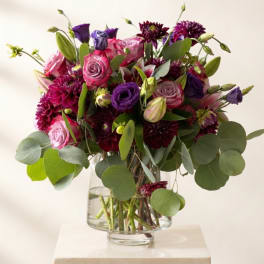 Bouquet of pink and purple flowers in a clear glass vase