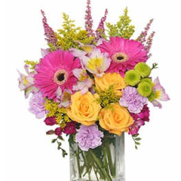 Colorful bouquet of gerbera daisies, roses, and alstroemeria in a glass vase