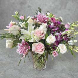 Pink and white mixed flower arrangement in a textured glass vase