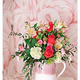 Pink and red rose bouquet in a white pitcher vase