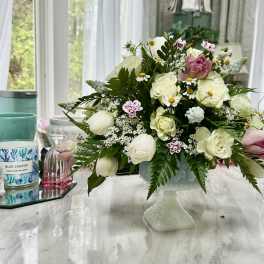 White and pink floral arrangement in a pedestal vase