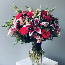 Bouquet of pink roses and lilies in a clear glass vase