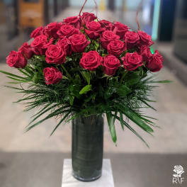 Bouquet of red roses in a tall glass vase