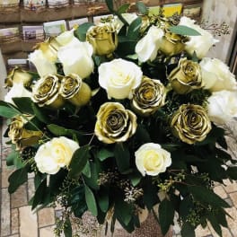 Bouquet of white and gold roses with dark green foliage