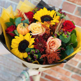 Bouquet of sunflowers and roses wrapped in yellow and black paper