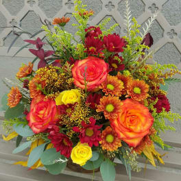 Mixed bouquet of roses and daisies in a basket