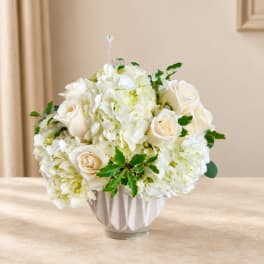 White hydrangea and cream rose arrangement in a ribbed vase