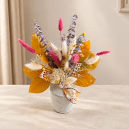 Autumn floral arrangement in a speckled vase with pink accents