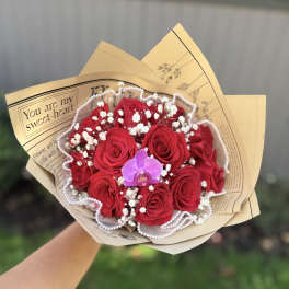 Bouquet of red roses with white baby's breath and a purple orchid
