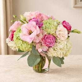 Pink and white flower bouquet in a clear glass vase