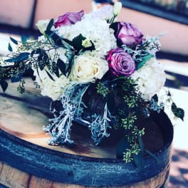 Bouquet of white and purple roses with white hydrangeas in a glass vase