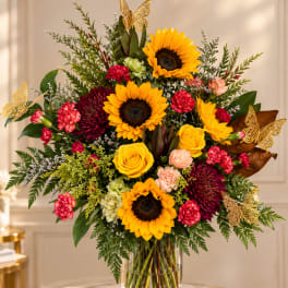 Bouquet of sunflowers, roses, and chrysanthemums in a glass vase