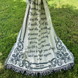 Memorial blanket draped outdoors with a large white bow