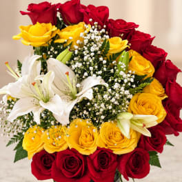 Bouquet of red and yellow roses with white lilies and baby's breath
