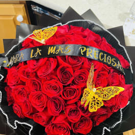 Round bouquet of red roses with black wrap and yellow butterfly decorations