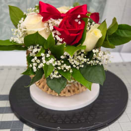 Red and white roses with baby's breath in a basket