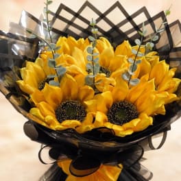Bouquet of yellow sunflowers wrapped in black paper