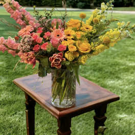 Colorful mixed bouquet in a clear glass vase on a wooden table