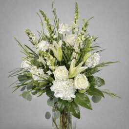 White roses and lilies in a clear glass vase