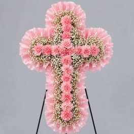Pink floral cross-shaped standing arrangement on an easel
