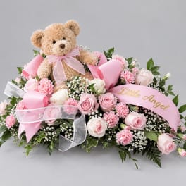 Pink rose arrangement with a teddy bear and ribbon banner